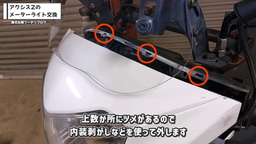 ヘッドライトの上部にある数カ所のツメを外します。